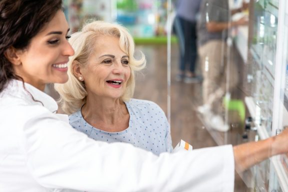 Twee vrouwen kijken blij naar een automaat met gezondheidsproducten.